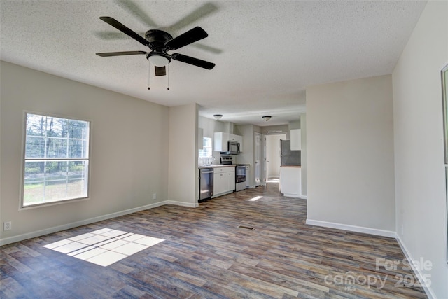 unfurnished living room featuring a textured ceiling, baseboards, and dark wood finished floors