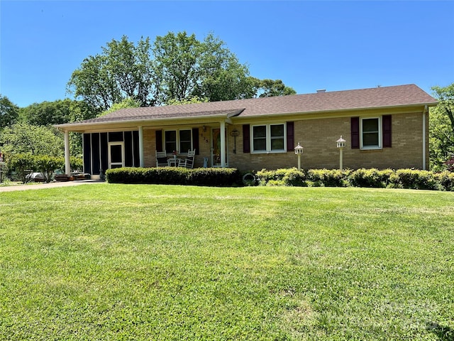 ranch-style house featuring a porch, brick siding, and a front yard