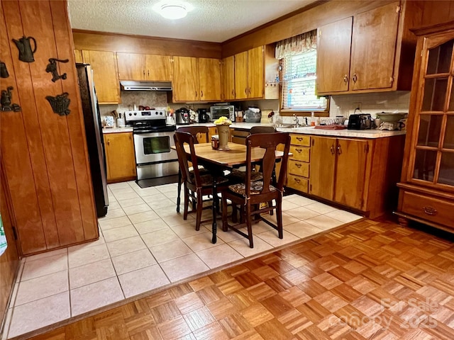 kitchen with brown cabinetry, extractor fan, light countertops, a textured ceiling, and stainless steel appliances
