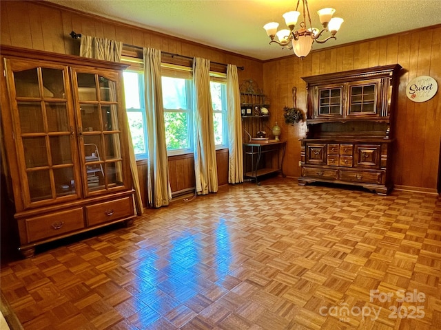 dining room featuring wooden walls and a notable chandelier