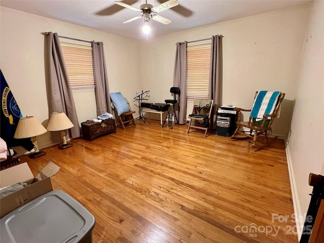 living area with a ceiling fan and light wood finished floors