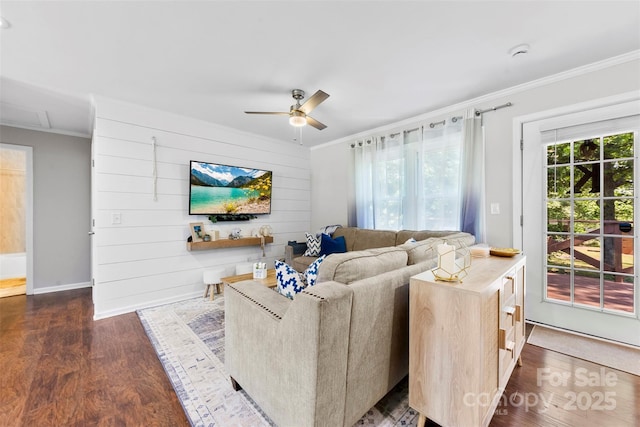 living area with crown molding, baseboards, dark wood finished floors, and ceiling fan