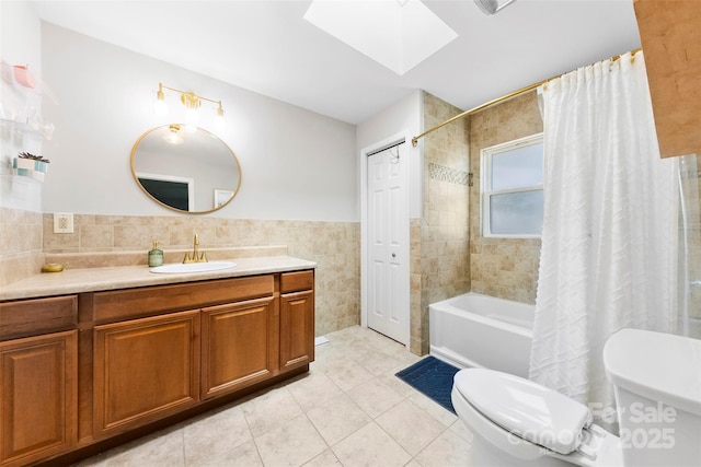 full bath featuring toilet, tile patterned floors, tile walls, shower / tub combo, and a skylight
