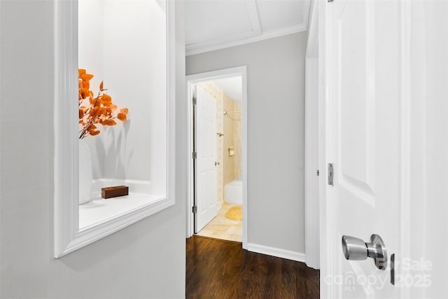 corridor with crown molding, baseboards, and dark wood-type flooring