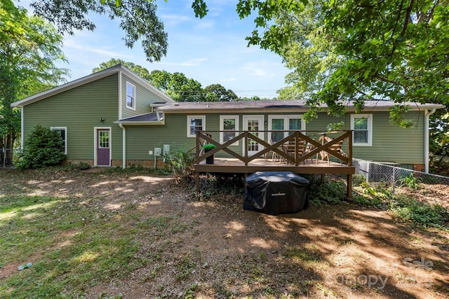 rear view of property with fence and a wooden deck