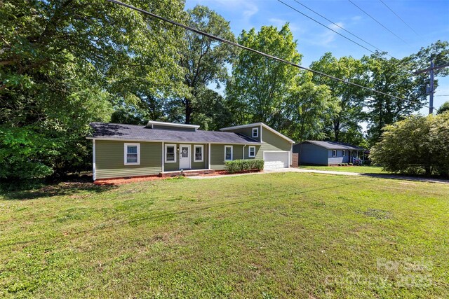 view of front of property with an attached garage, an outdoor structure, a front lawn, and concrete driveway