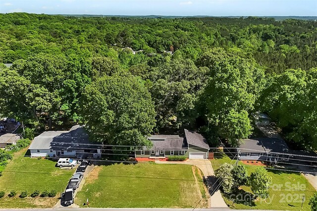 birds eye view of property featuring a wooded view