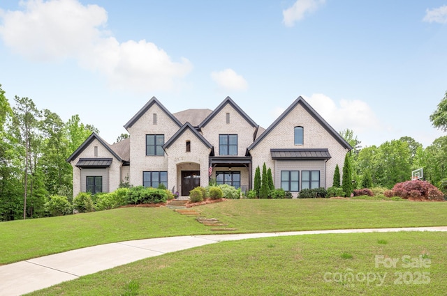 french country home featuring brick siding and a front lawn
