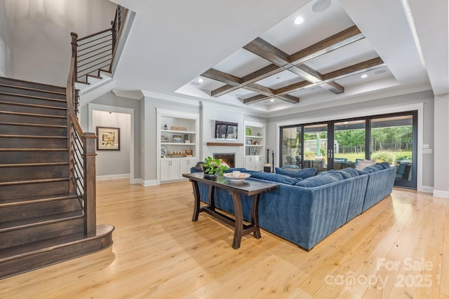 living area featuring baseboards, light wood-style floors, and beam ceiling