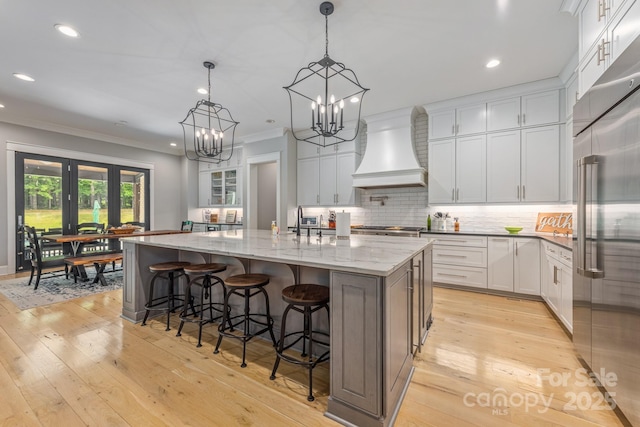 kitchen with custom exhaust hood, stainless steel built in fridge, recessed lighting, and ornamental molding