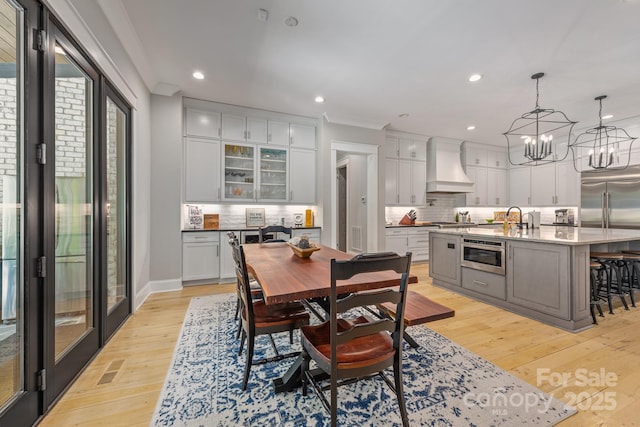 dining room featuring recessed lighting, ornamental molding, light wood finished floors, visible vents, and a notable chandelier
