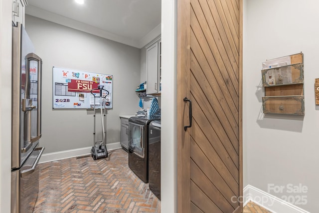 laundry room featuring baseboards, recessed lighting, separate washer and dryer, cabinet space, and brick floor