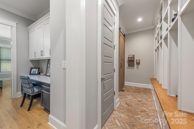 hallway featuring ornamental molding, recessed lighting, a barn door, and baseboards