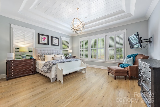 bedroom with a raised ceiling, baseboards, a notable chandelier, and light wood-style floors