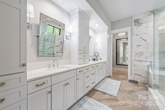 bathroom featuring double vanity, recessed lighting, a freestanding bath, and a sink