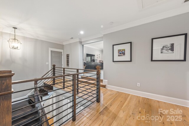 hallway with crown molding, an upstairs landing, baseboards, light wood-type flooring, and recessed lighting