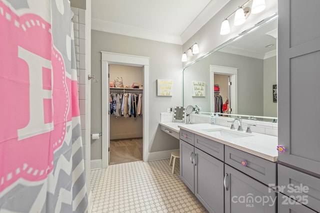 full bathroom with vanity, tile patterned floors, crown molding, baseboards, and a spacious closet