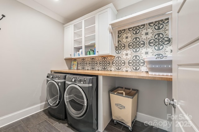 laundry area featuring cabinet space, dark tile patterned floors, independent washer and dryer, and baseboards