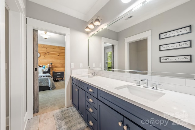 full bathroom with ensuite bathroom, double vanity, a sink, and visible vents