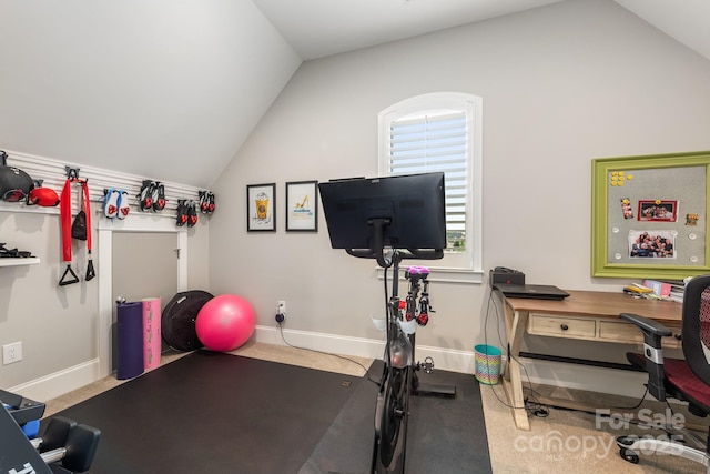 exercise room featuring vaulted ceiling and baseboards