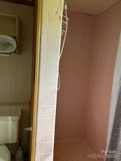 bathroom with toilet and a tile shower