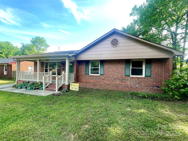 single story home with a porch, a front lawn, and brick siding