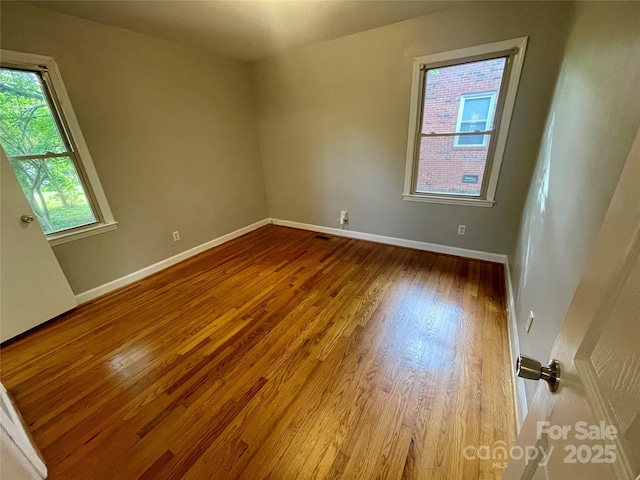 empty room with wood finished floors and baseboards