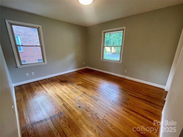 spare room with wood finished floors and baseboards