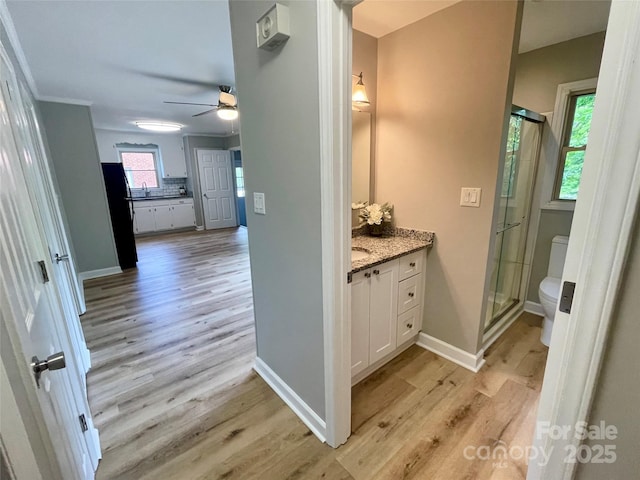 bathroom with toilet, a shower stall, and wood finished floors