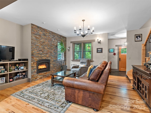29 Ravenna St, Asheville, NC 28803 - living area featuring wood finished floors, a stone fireplace, a chandelier, and stairs