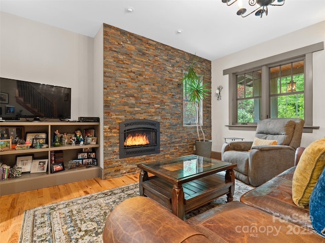 29 Ravenna St, Asheville, NC 28803 - living area with a warm lit fireplace, wood finished floors, stairs, and a chandelier