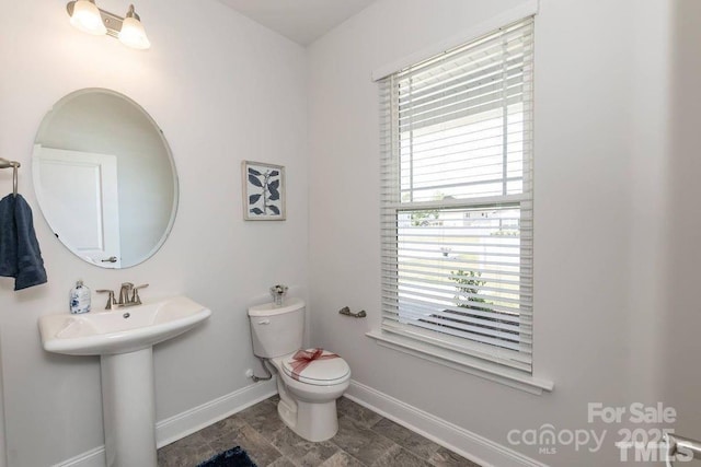 bathroom with toilet and baseboards