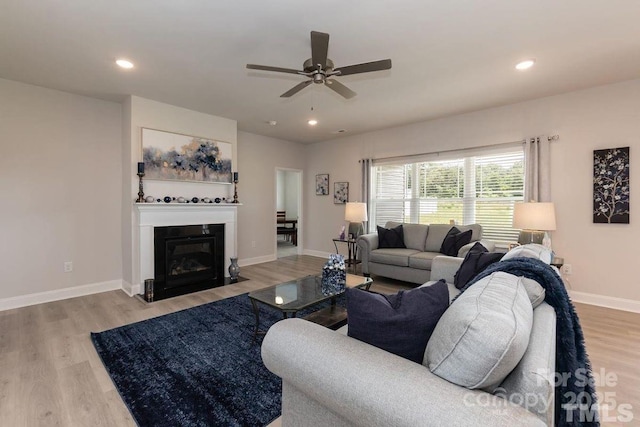 living area featuring baseboards, recessed lighting, a ceiling fan, and light wood-style floors
