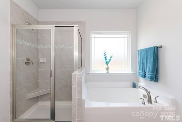 bathroom featuring a shower stall and a bath
