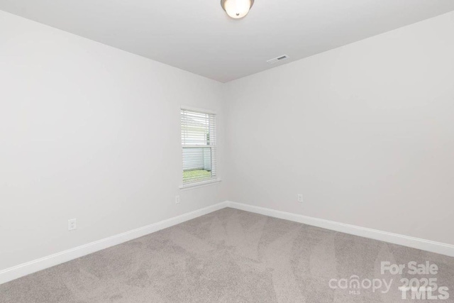 carpeted spare room featuring visible vents and baseboards