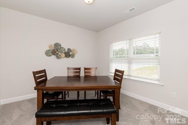 dining area with visible vents, baseboards, and light carpet