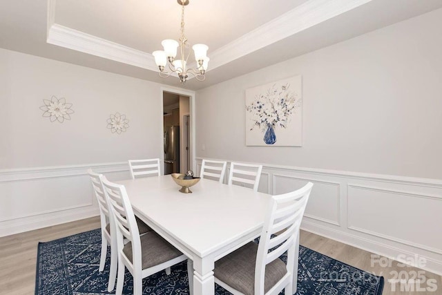 1479 Mocksville Hwy Unit 23, Statesville, NC 28625 - dining space with light wood-type flooring, a chandelier, crown molding, a decorative wall, and a wainscoted wall