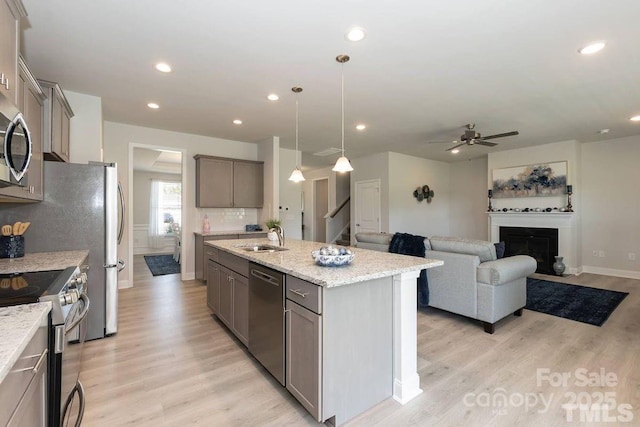 1479 Mocksville Hwy Unit 23, Statesville, NC 28625 - kitchen with appliances with stainless steel finishes, a sink, ceiling fan, light wood-style floors, and an island with sink