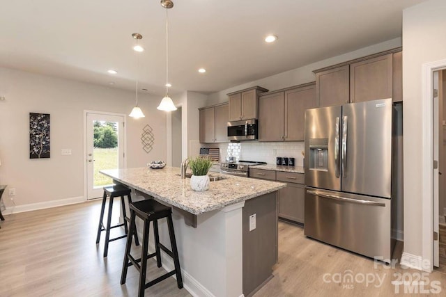 1479 Mocksville Hwy Unit 23, Statesville, NC 28625 - kitchen with appliances with stainless steel finishes, a sink, light wood finished floors, an island with sink, and backsplash