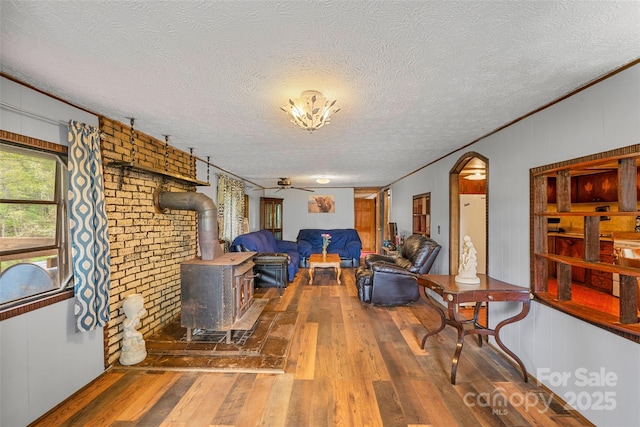68 Upper White Oak Rd, Mars Hill, NC 28754 - living area featuring a wood stove, hardwood / wood-style flooring, a ceiling fan, a textured ceiling, and ornamental molding