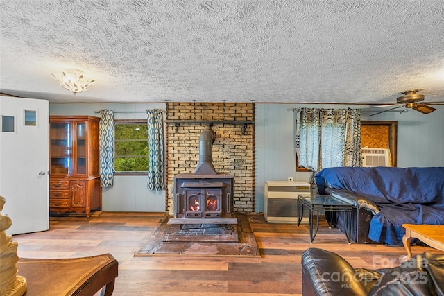 68 Upper White Oak Rd, Mars Hill, NC 28754 - living area featuring hardwood / wood-style floors, a textured ceiling, a wood stove, a ceiling fan, and ornamental molding