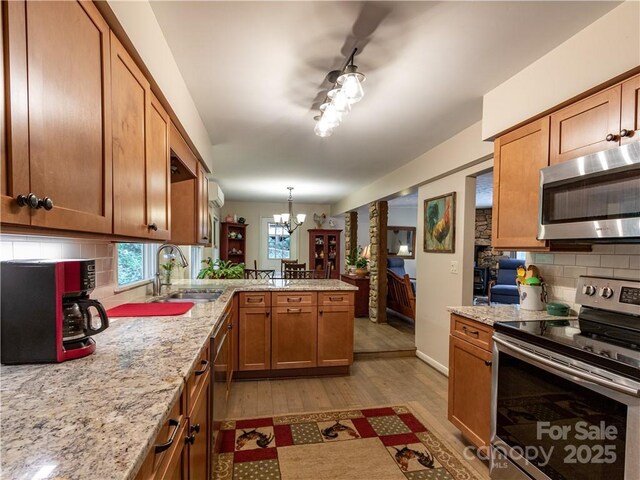 597 Sweetwater Rdg, Burnsville, NC 28714 - kitchen featuring stainless steel appliances, a peninsula, wood finished floors, a chandelier, and decorative backsplash