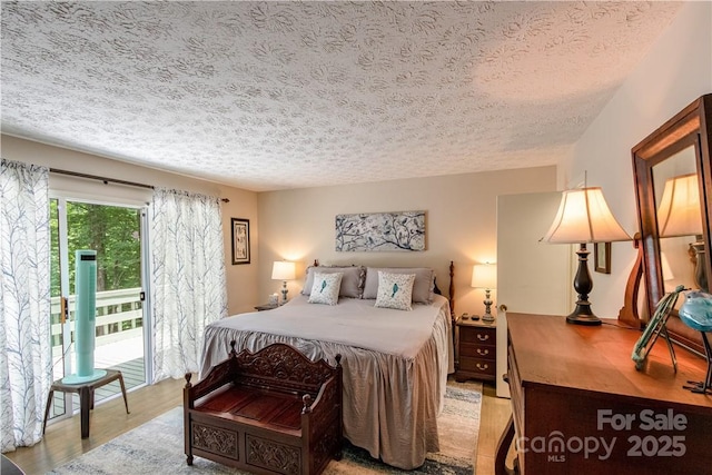 597 Sweetwater Rdg, Burnsville, NC 28714 - bedroom featuring a textured ceiling, light wood-style floors, and access to exterior
