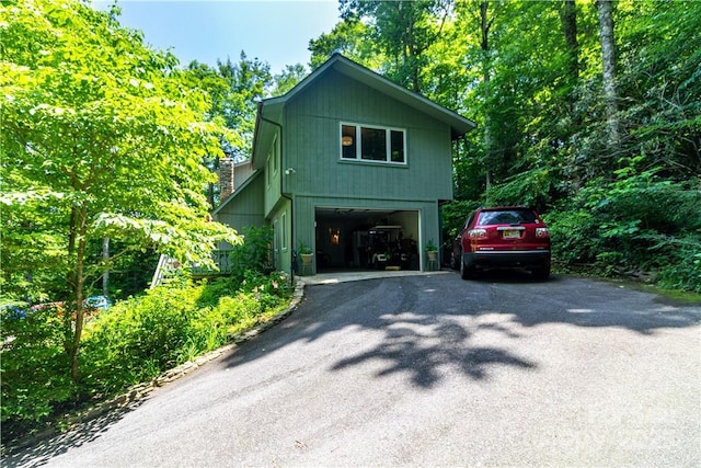 597 Sweetwater Rdg, Burnsville, NC 28714 - view of home's exterior with asphalt driveway, a detached garage, and a chimney