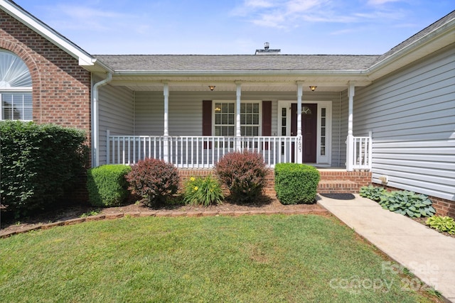 260 Treebark Rd, Statesville, NC 28625 - view of exterior entry with a yard, a porch, brick siding, a chimney, and roof with shingles