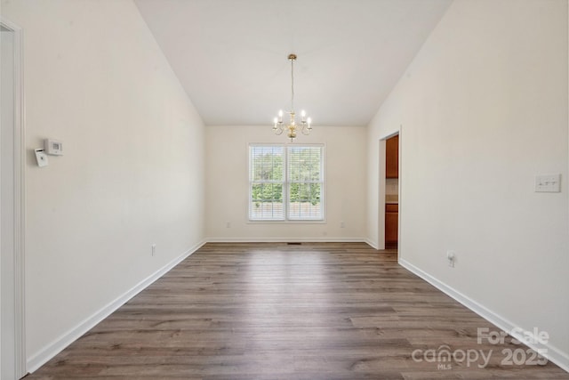 260 Treebark Rd, Statesville, NC 28625 - empty room featuring a chandelier, vaulted ceiling, dark wood finished floors, and baseboards
