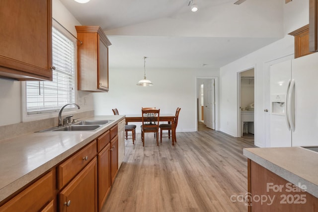260 Treebark Rd, Statesville, NC 28625 - kitchen with a sink, white appliances, brown cabinets, light wood finished floors, and vaulted ceiling