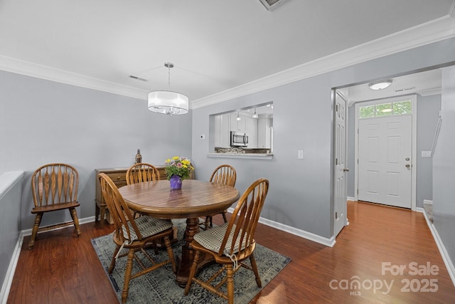 3736 Melrose Cottage Dr, Matthews, NC 28105 - dining room with baseboards, ornamental molding, wood finished floors, and visible vents