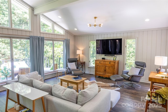 living room featuring lofted ceiling with beams, a notable chandelier, wood finished floors, and plenty of natural light