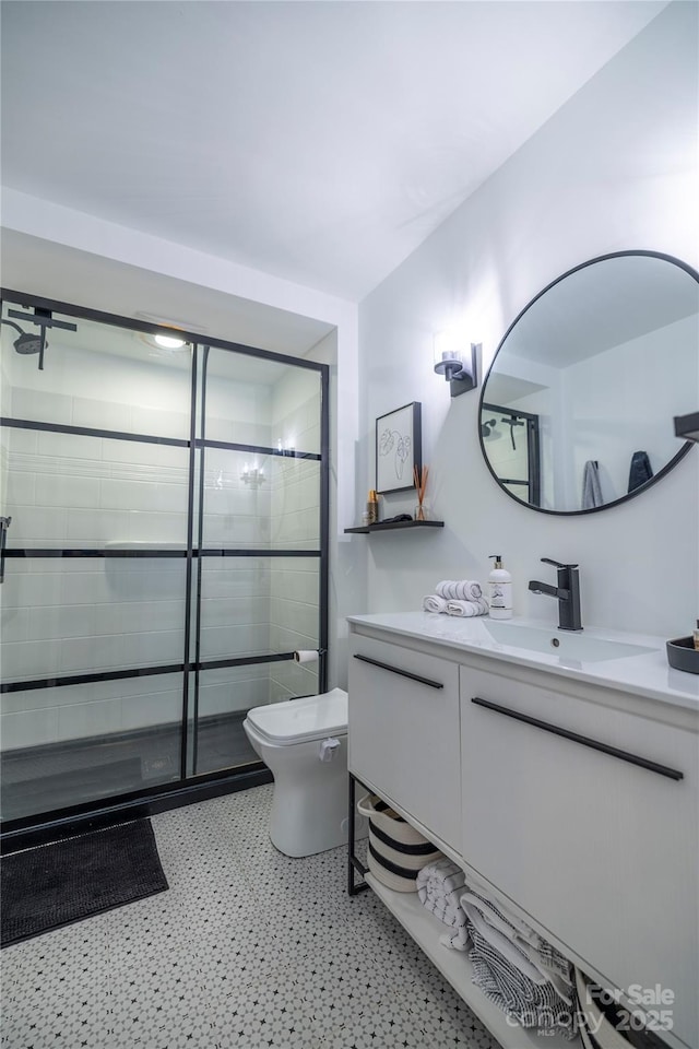 full bathroom featuring tile patterned floors, vanity, toilet, and tiled shower